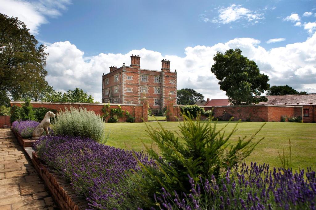 un jardín con flores púrpuras frente a un edificio en Soulton Hall, en Wem