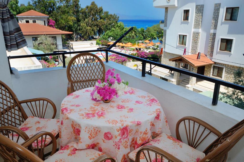 een tafel en stoelen met bloemen op een balkon bij Kaya Apart Datca in Datca