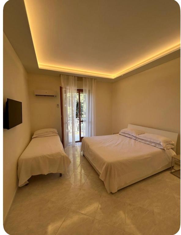 a bedroom with two beds and a flat screen tv at Dream on the blue house 2 in Valderice