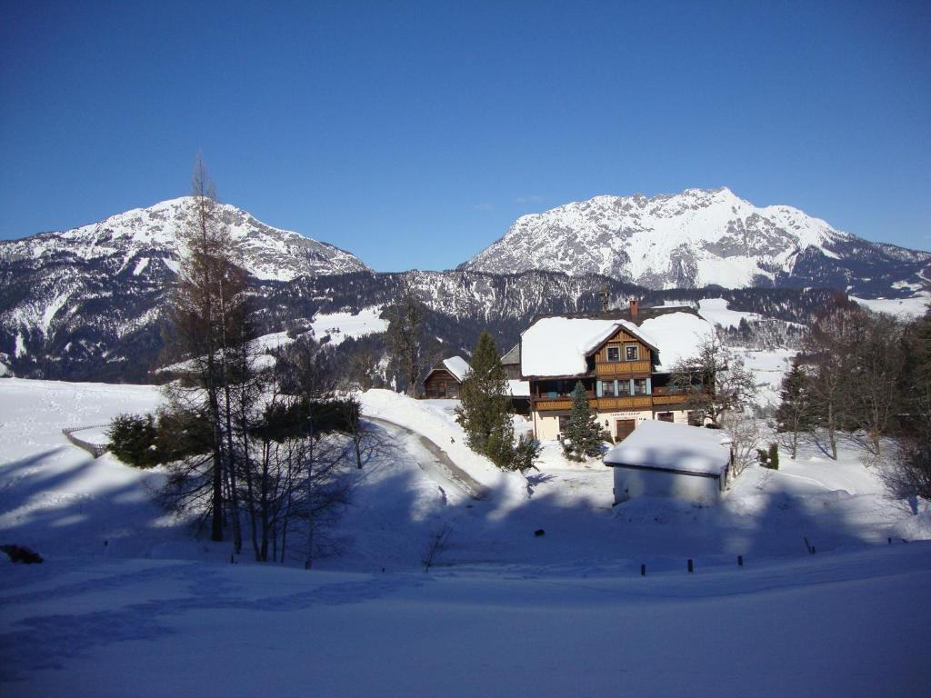 a house in the snow in front of a mountain at Farmreiterhof in Pruggern