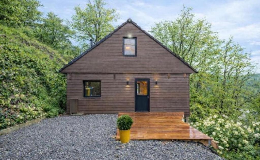 a small wooden house with a potted plant in front at Gites Douillets Chalet du Vicomte in Houyet