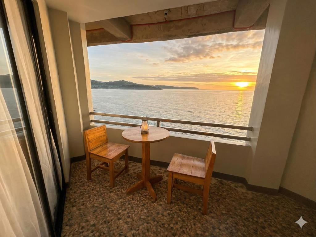 a room with a table and chairs and a view of the ocean at Marjhun's Apartelle in Jagna