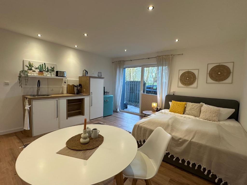 a bedroom with a bed and a table and a kitchen at Deich Quartier 9.2 in Dorum-Neufeld