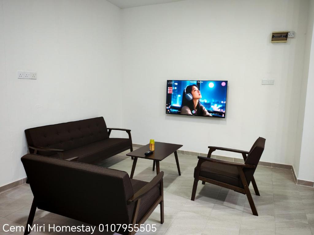 a living room with a couch and a tv on the wall at Cem Miri Homestay 2 in Miri
