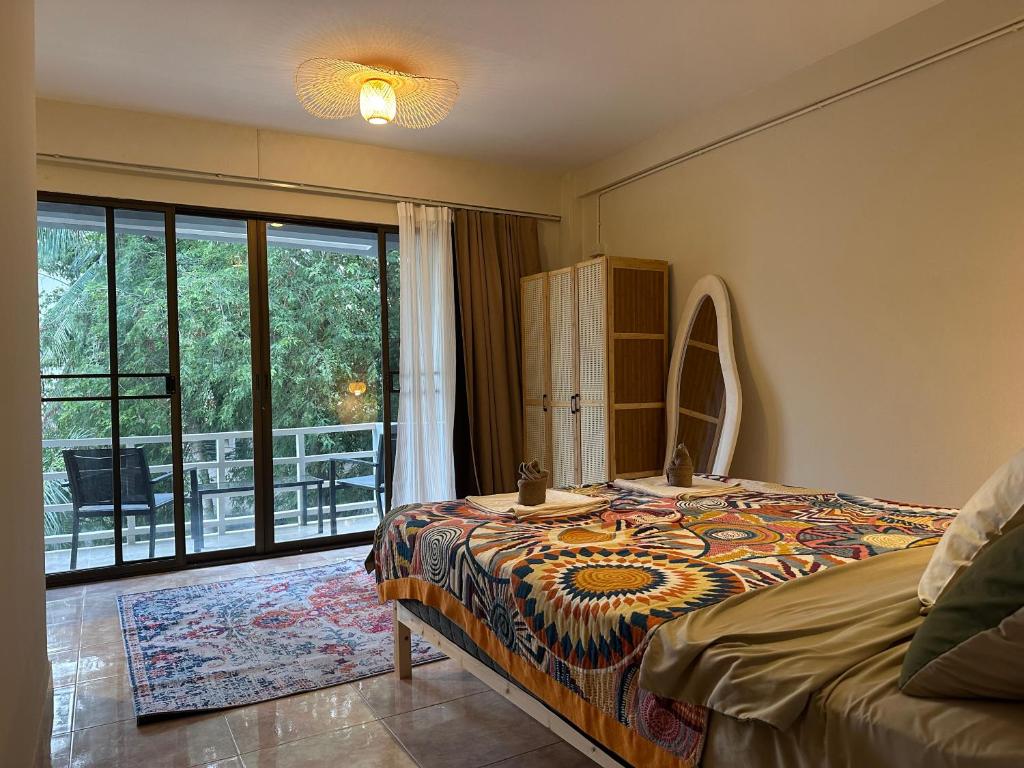 a bedroom with a bed and a large window at Nest by Aerial Lanta in Ko Lanta