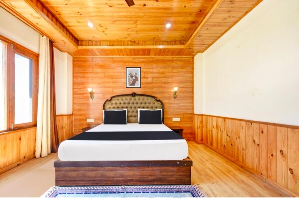 a bedroom with a large bed in a wooden room at Royal Ocean COTTAGE in Manāli