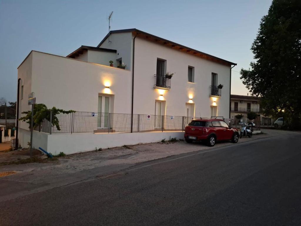 a red car parked in front of a white building at b&b Vitae in Tremensuoli