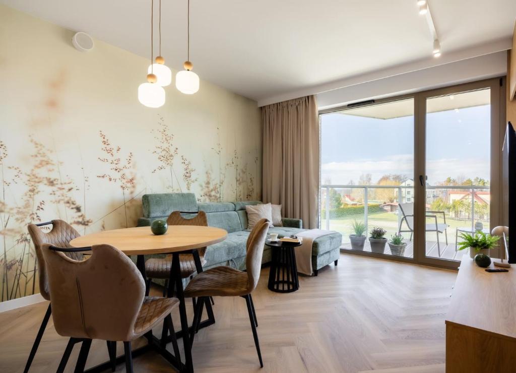 a living room with a table and a couch at Apartament Harmonia Baltic in Sarbinowo