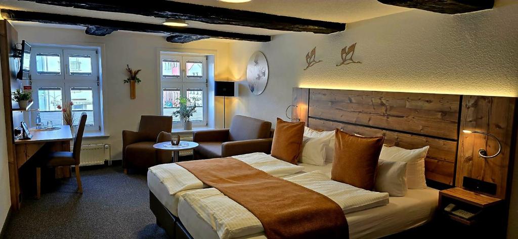 a hotel room with a large bed and a desk at Hotel Am Markt & Brauhaus Stadtkrug in Ueckermünde