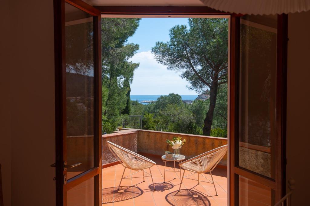 a room with a balcony with a table and chairs at Villa Fornaci - Marina di Campo in Marina di Campo