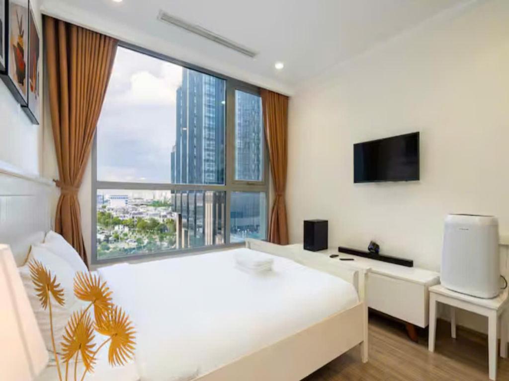 a white bedroom with a large window and a white bed at Landmark City View - Apartment in Ho Chi Minh City