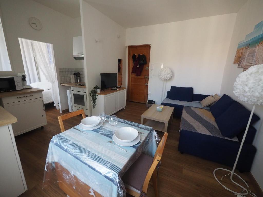 a living room with a table and a couch at Le Picaflor YourHostHelper in Hyères
