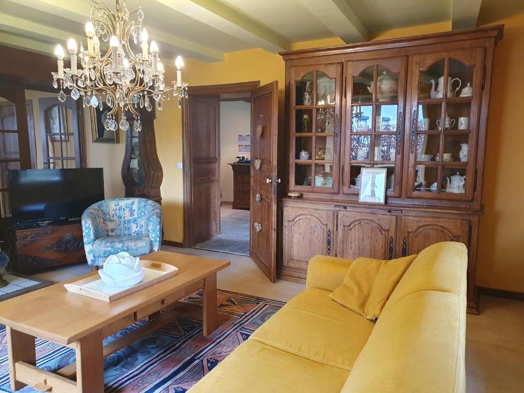 a living room with a couch and a chandelier at Sur la Rive Vierre in Suxy