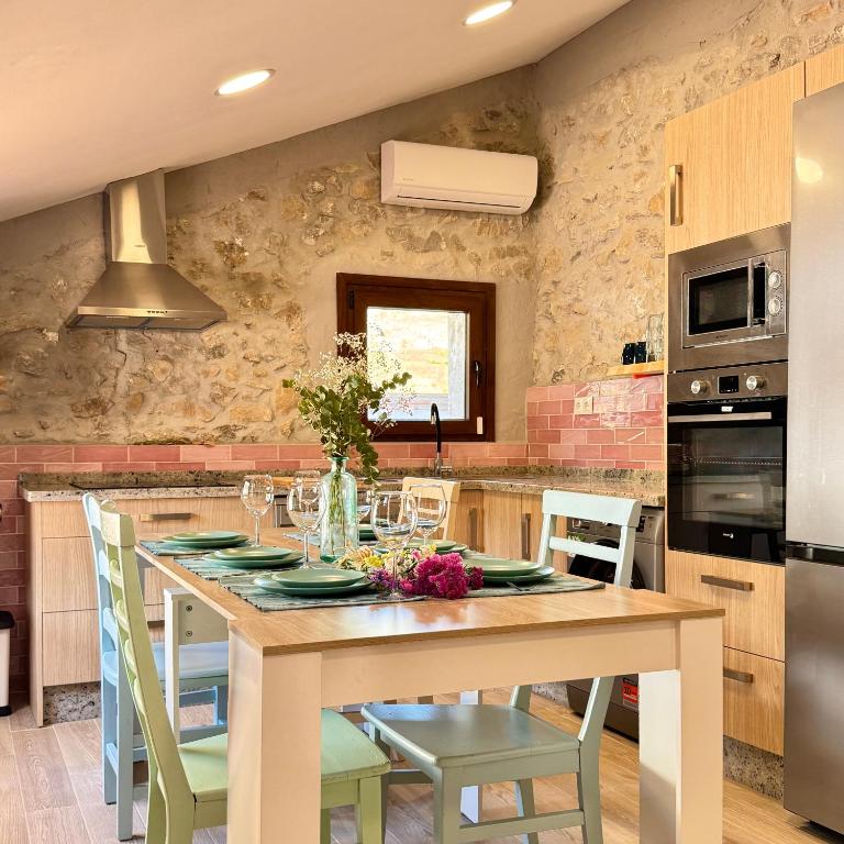 a kitchen with a wooden table with green chairs at Villa Jimena in Periana