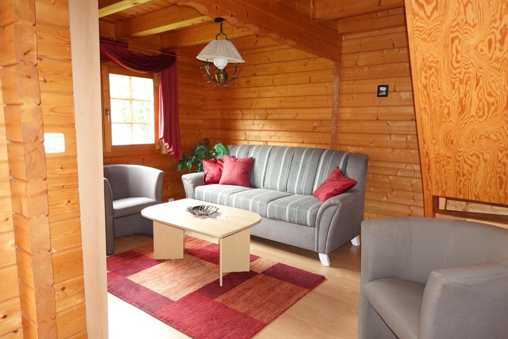 a living room with a couch and a table at Ferienhaus Großmann in Drognitz