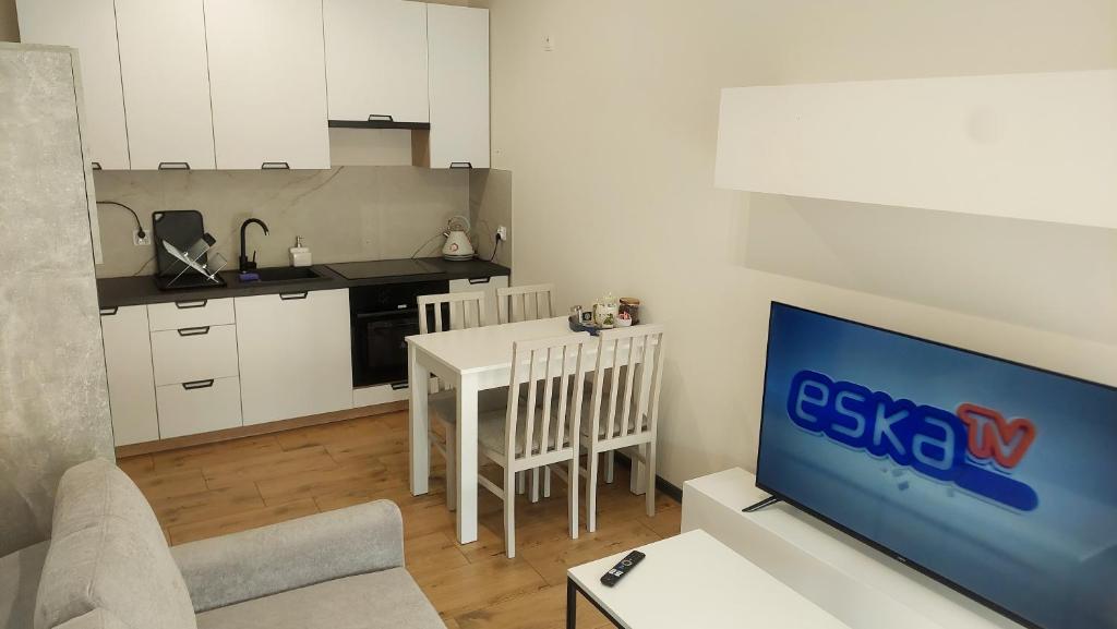a living room with a tv and a kitchen at MagMar Studio Kluczbork Rynek Premium in Kluczbork