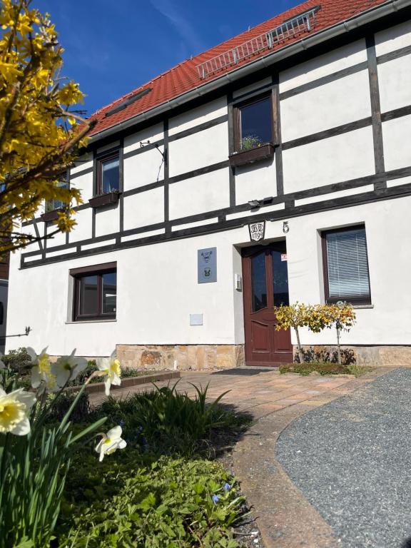 a white building with a red roof at Ferienwohnung "Am Malerweg" Lohmen in Lohmen