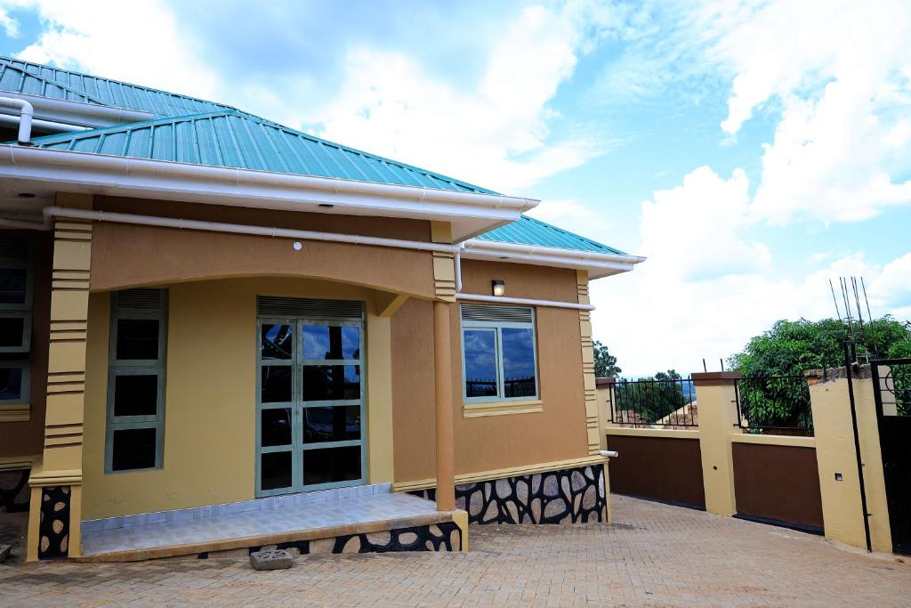 a small yellow house with a blue roof at Two-bedroom unit in Mubende Town in Mubende
