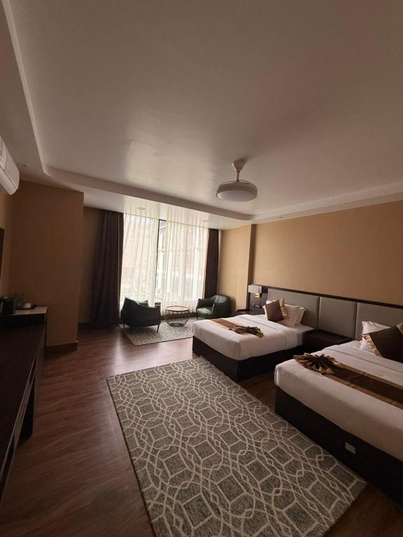 a hotel room with two beds and a rug at Tara Haven Hotel in Yuwak