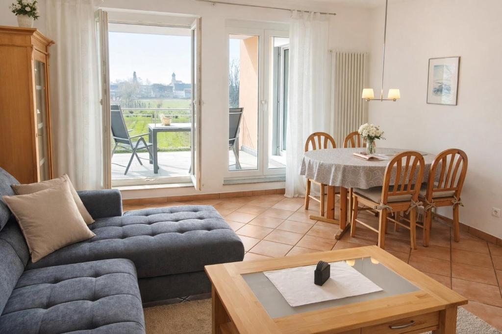 a living room with a couch and a table at Haus Sonnenseite Wohnung Säntis in Wasserburg