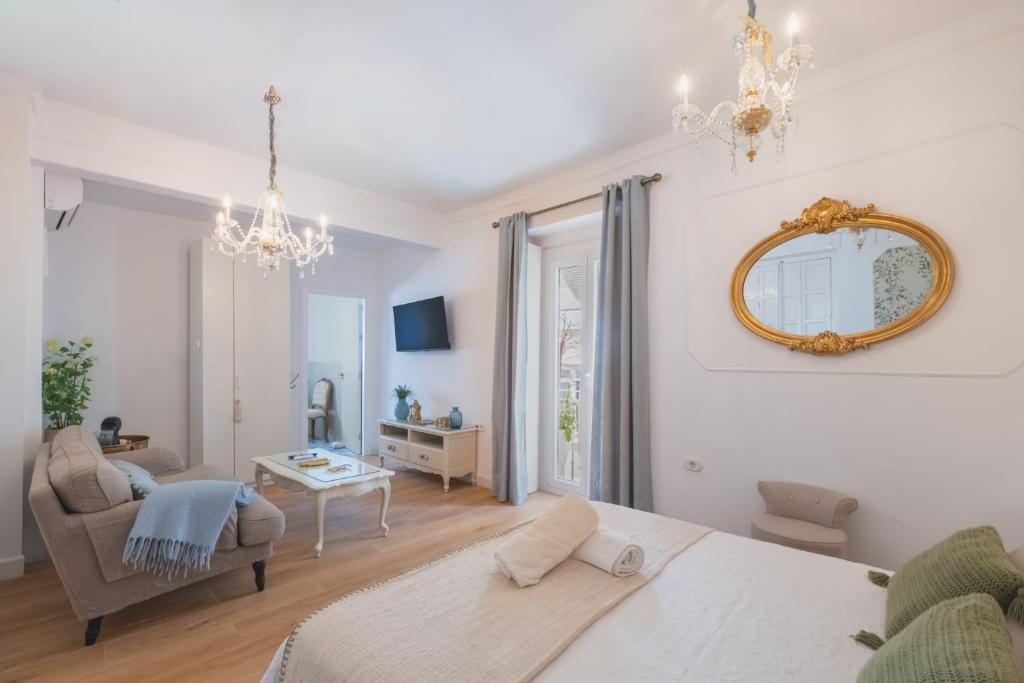 a living room with a bed and a mirror at Palacete de La Alameda - Adults Only- in Cádiz