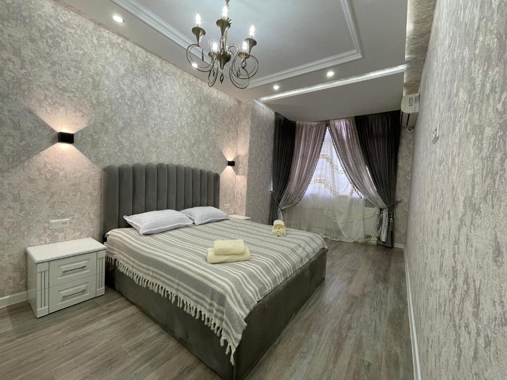 a bedroom with a large bed and a chandelier at Luxanda Samarkand in Samarkand