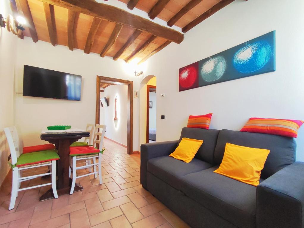 a living room with a blue couch and a table at Le Torri 3 San Gimignano in San Gimignano