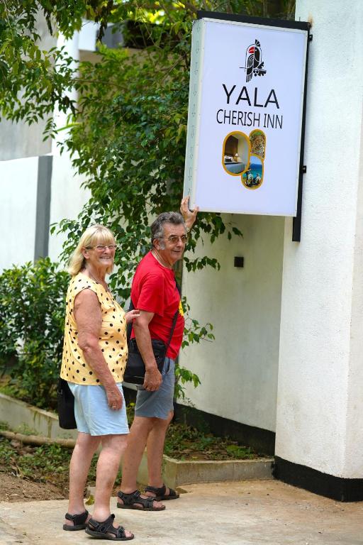 a man and a woman standing in front of a sign at Yala Cherish Inn & Safari in Tissamaharama