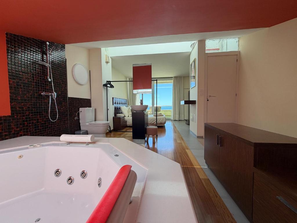 ein großes Badezimmer mit Badewanne und ein Wohnzimmer in der Unterkunft VILA TABARCA QUALITY & LUXURY in Tabarca