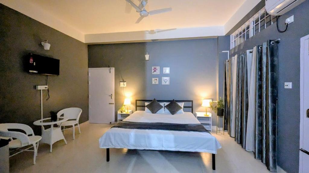 a bedroom with a bed and a table and chairs at HO6 Homestay in Guwahati