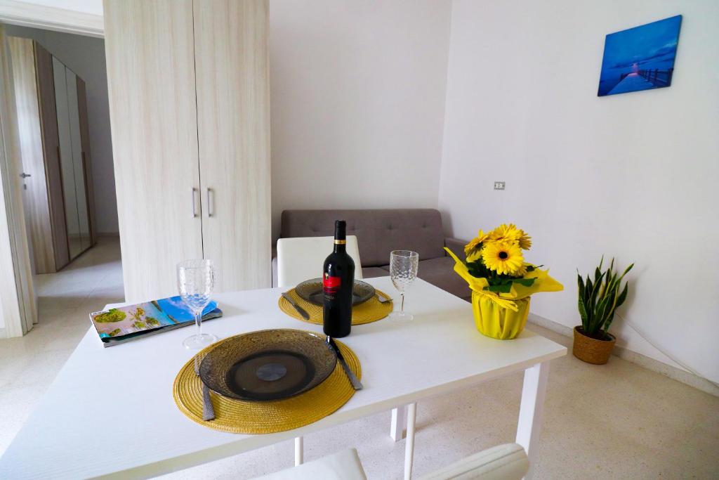 a white table with a bottle of wine and glasses at Elaia's House in Cannole in Cannole