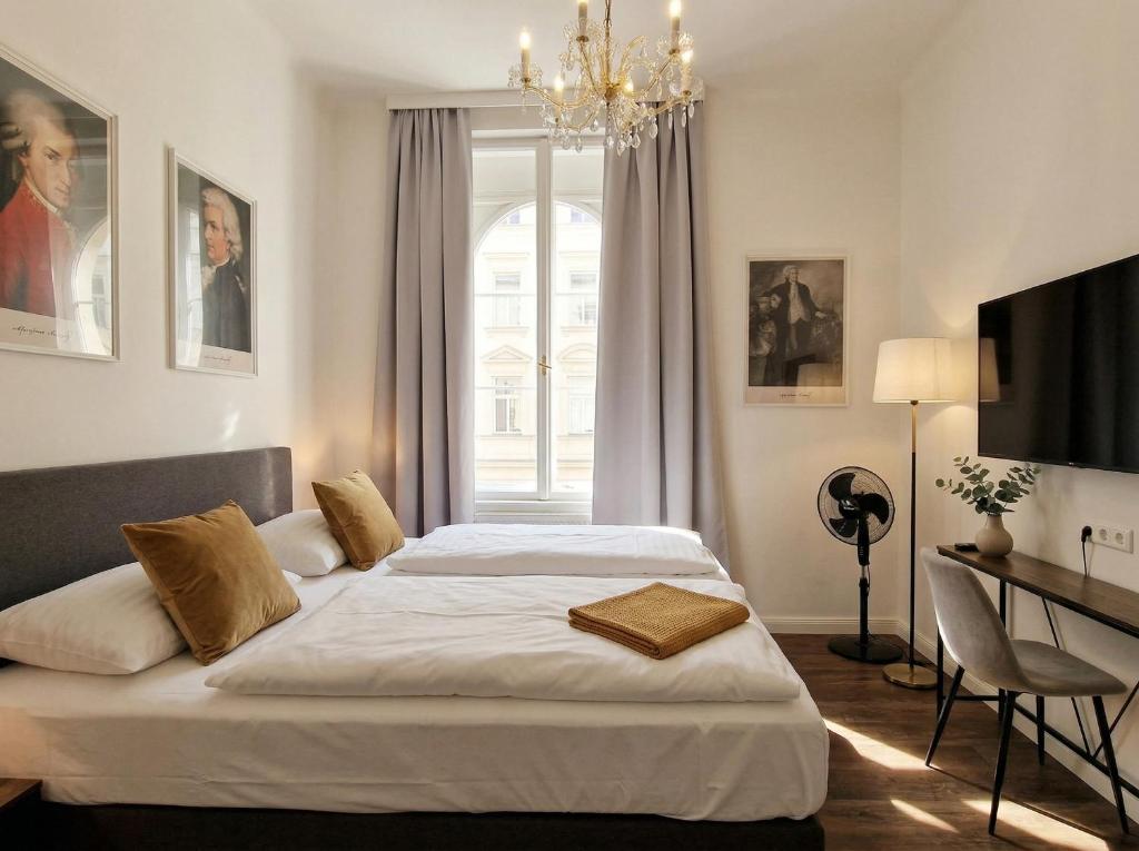 a bedroom with two beds and a chandelier at Pension Mozart - Vienna Center, Self Check-in in Vienna