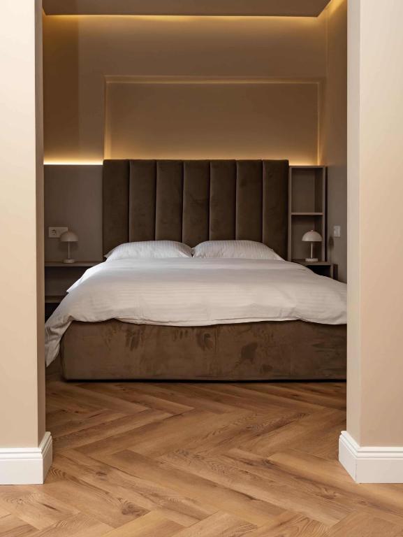 a bedroom with a large bed and a wooden floor at Distinct Ultracentral Apartment in Bistriţa
