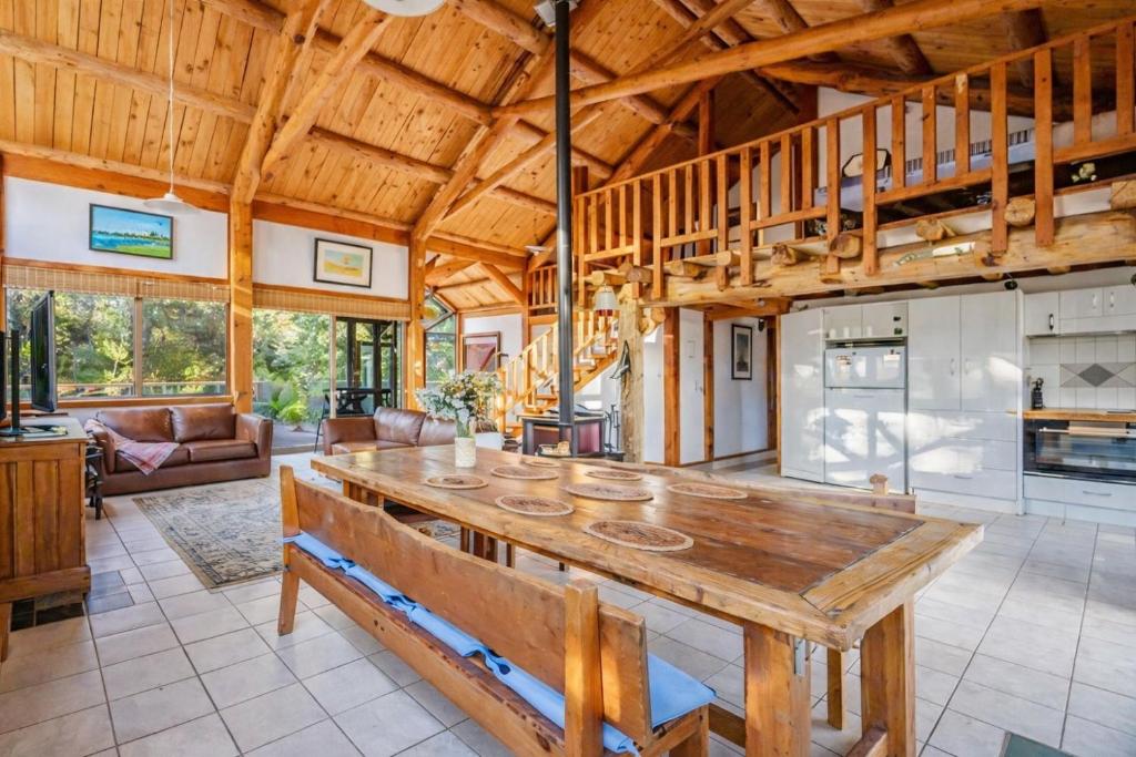a dining room with a wooden table and a kitchen at Yallingup Surfing wineries and restaurants in Yallingup