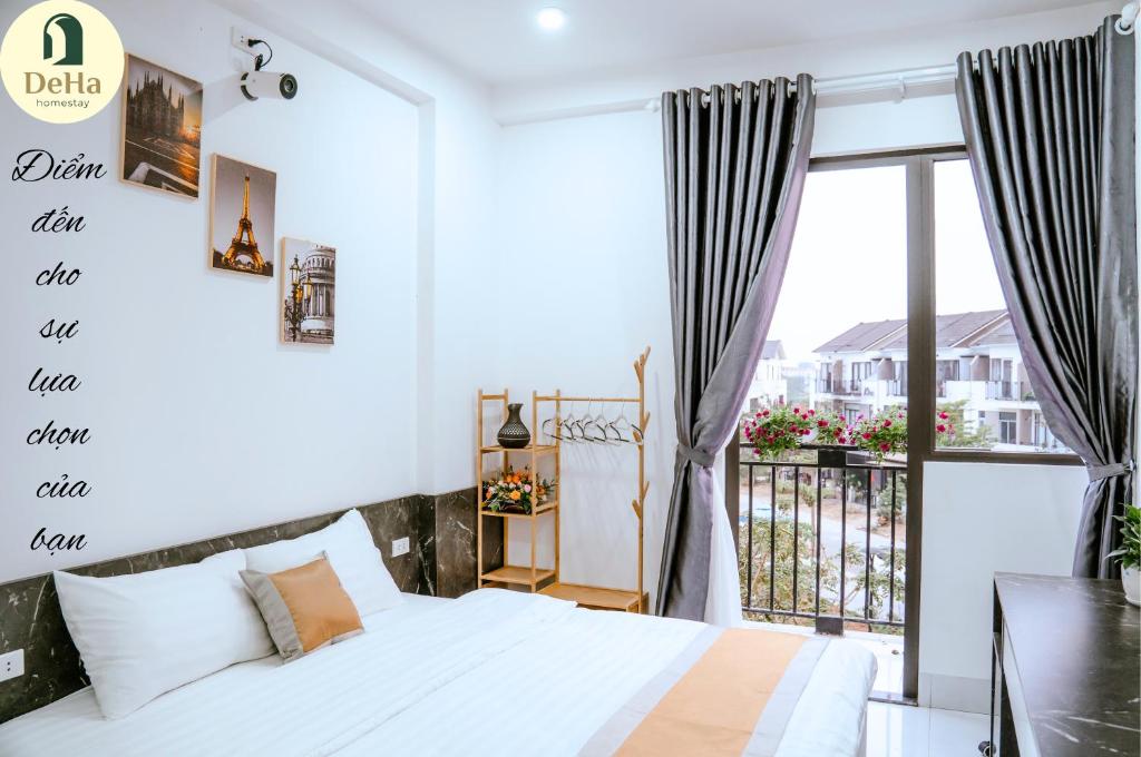 a bedroom with a white bed and a balcony at DeHa Homestay in Kon Rung (1)