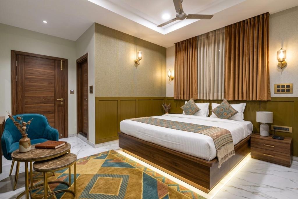 a hotel room with a bed and a table and a chair at Hotel Shumo Grand Khammam in Khammam