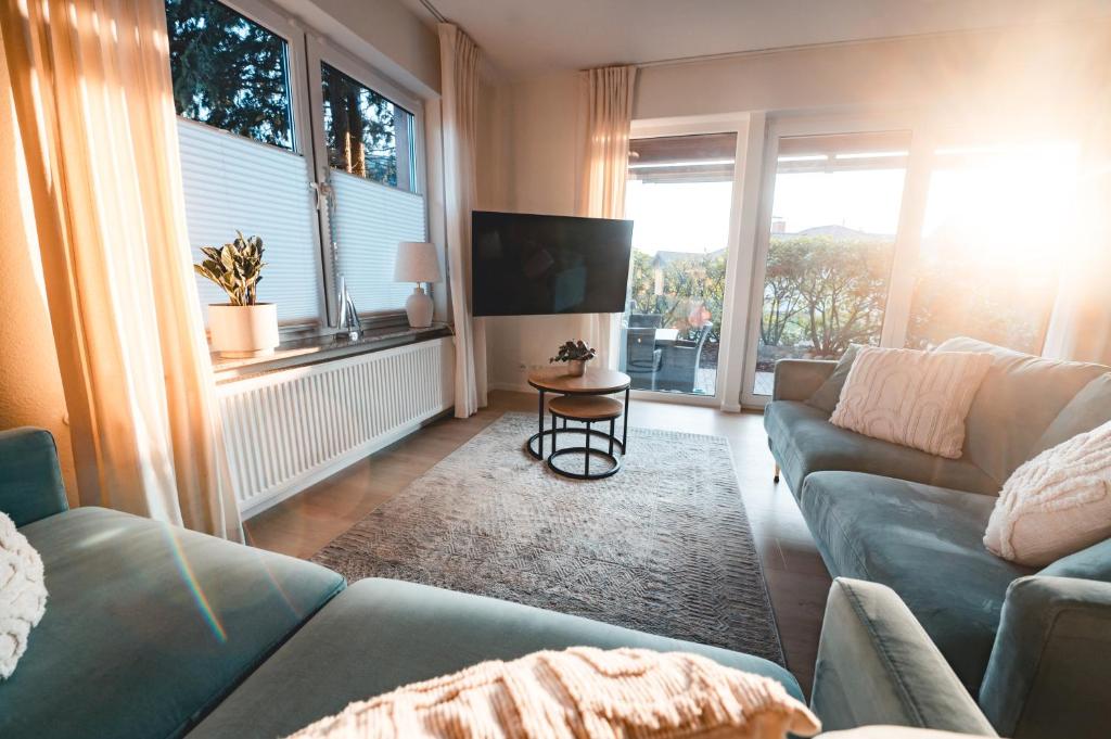 a living room with a couch and a table at Ferienhaus FachWerkPerle am Alfsee in Rieste