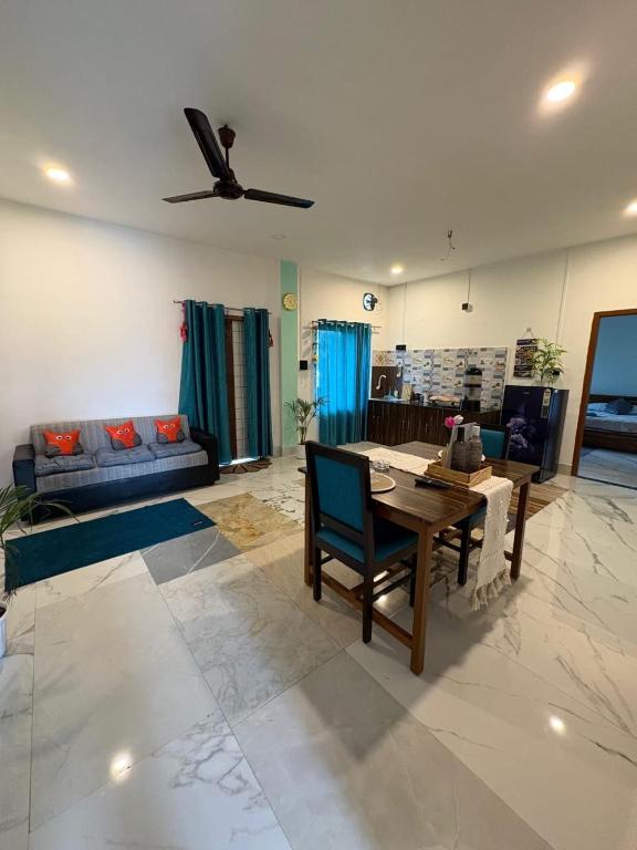 a living room with a table and a ceiling fan at Vasudha Homestay in Sibsāgar