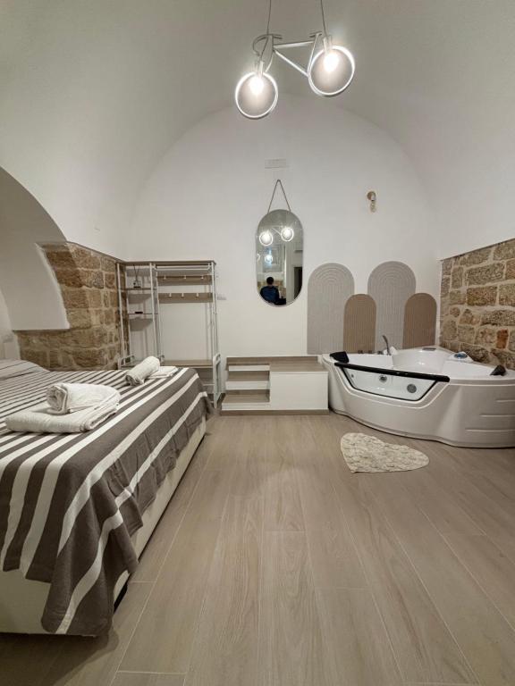 a bedroom with a bed and a bathtub and a bed and a sink at Marbella house con jacuzzi in Polignano a Mare