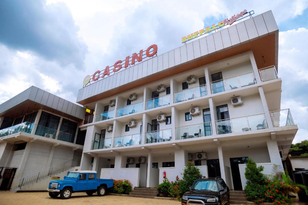 a building with a blue truck parked in front of it at Buffalo Village in Kigali