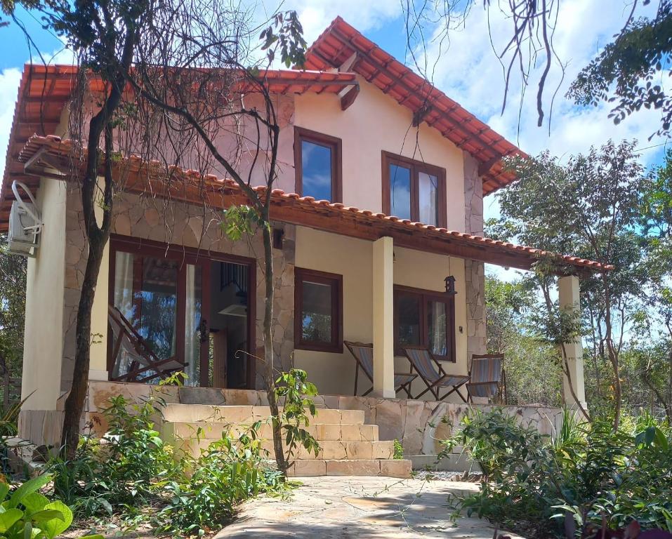 a house with a red roof and stairs in front at Chalé Colibri in Vale do Capao