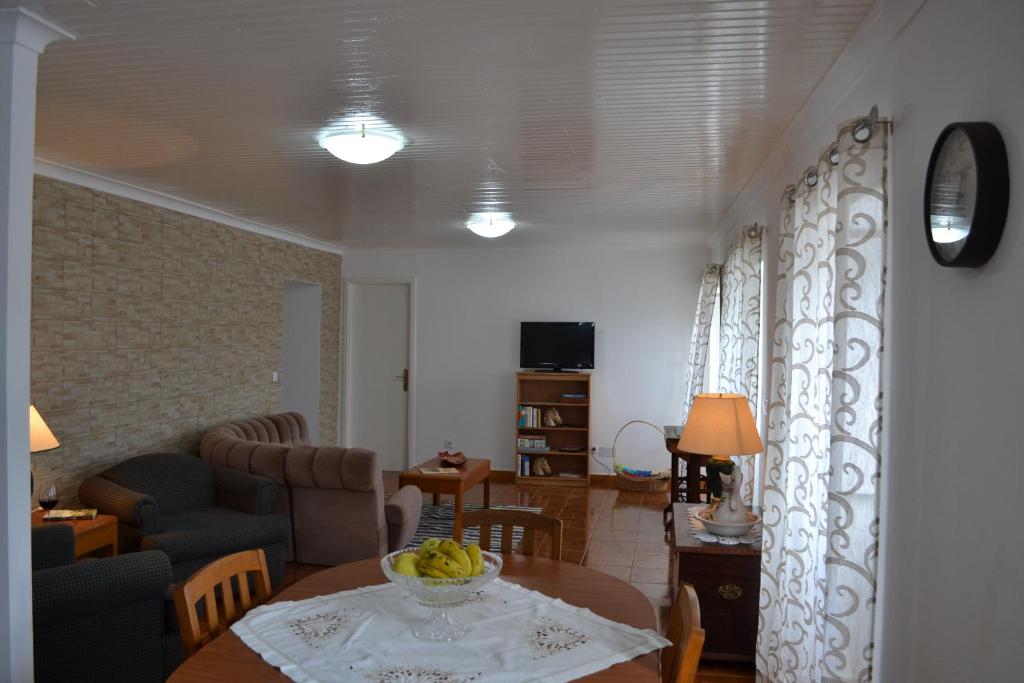 a living room with a table and a couch at Casa de Santa Catarina in Cabo da Praia