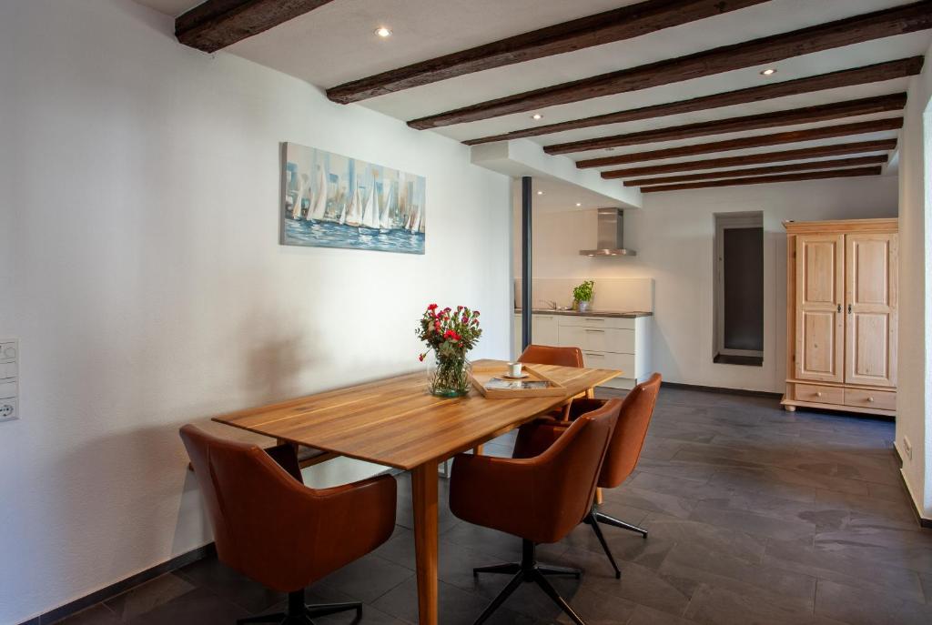 a dining room with a wooden table and chairs at Ferienhaus Carpe diem in Bodman-Ludwigshafen