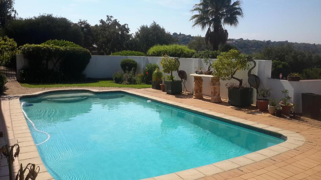 a swimming pool in the yard of a house at Chez Esme Guest House in Roodepoort