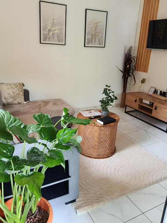 a living room with potted plants and a bed at Residence Naim in Sada
