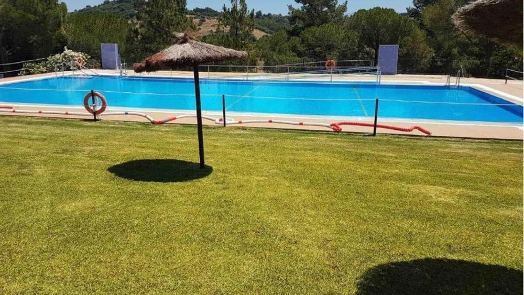 a umbrella in the grass next to a swimming pool at Luxe Vista in Serra