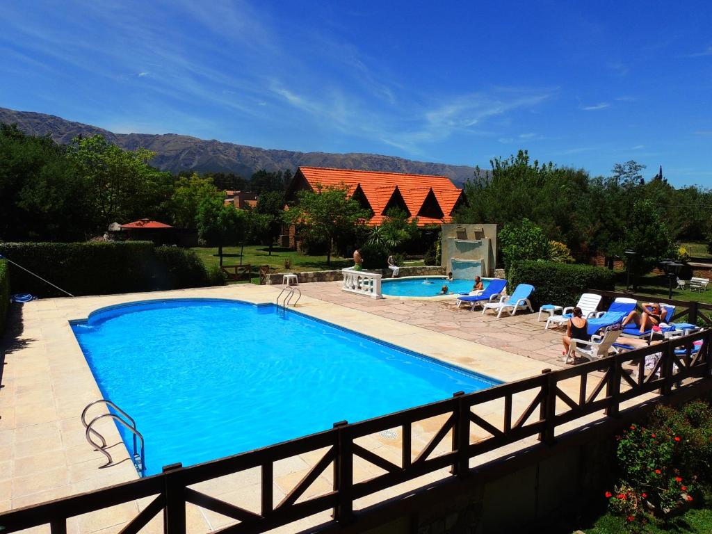 una gran piscina con una valla de madera alrededor en Le Marche Apart Hotel en Merlo