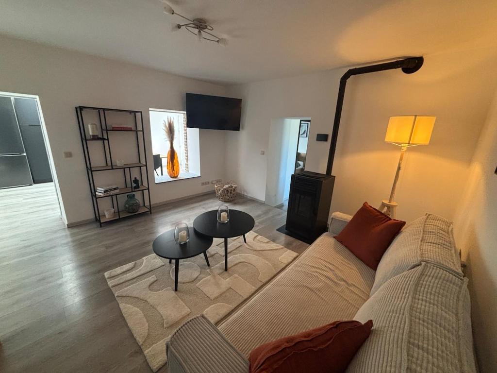 a living room with a couch and two tables at Appartement chez pépite in Namur