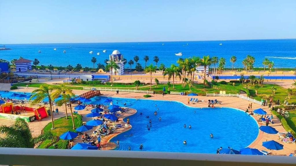a view of the beach and the pool at a resort at بورتو السخنه الاهرامات in Banī Ghālib