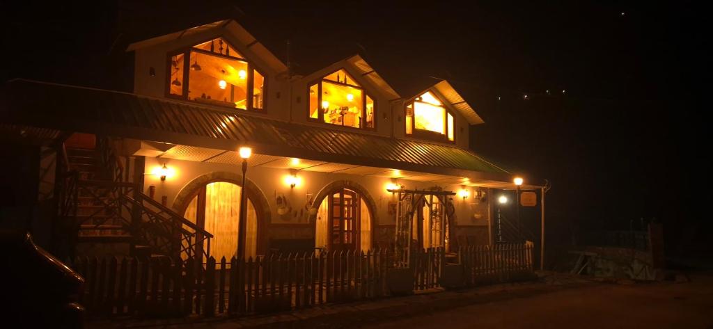 a house with lights on top of it at night at Roots & Rustle homestay in Kūfrī